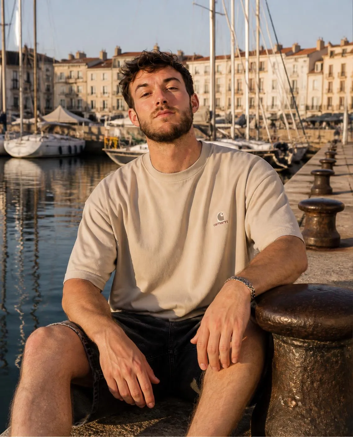 Cream T-shirt seated at the harbour
